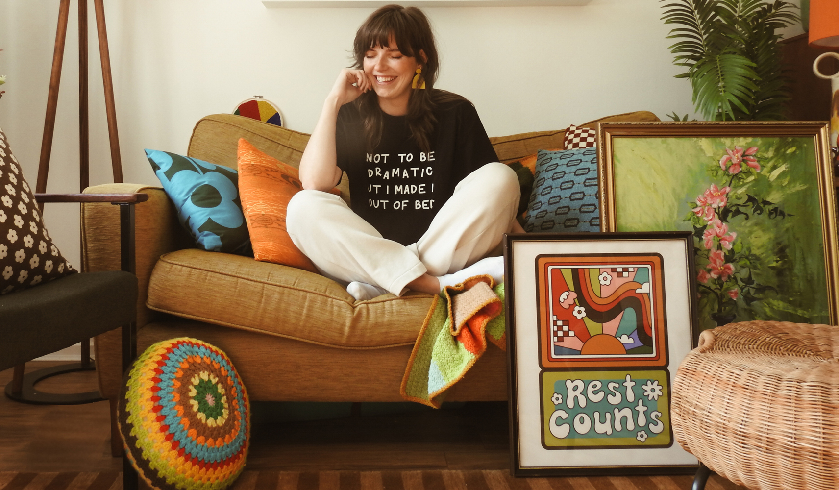 Jenny McGibbon sat at home on her sofa surrounded by her graphic prints.